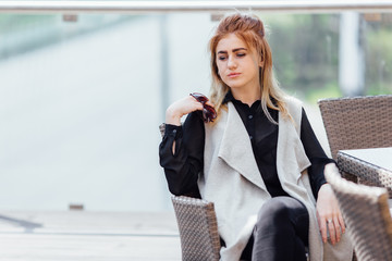 Woman sit near the table hold her glasses