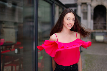 One girl pose to camera near the wall