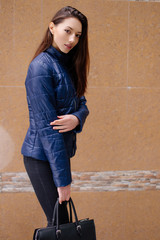 One girl pose to camera near the wall