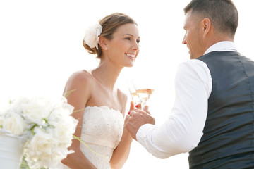 Happy bride and groom celebrating wedding with champagne