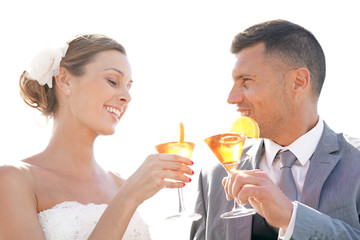 Bride and groom cheering with cocktails