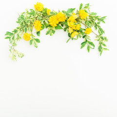 Floral frame made of branches with leaves and yellow flowers on white background. Flat lay, top view. Flowers and leaves