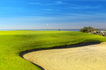 Obraz premium Green golf field on the sunny coast of Mediterranean sea