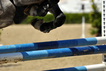 Pferdehufe mit Holme beim Sprung über das Hindernis