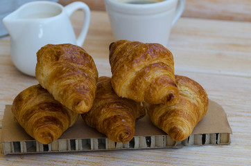 Group of tasty buttery croissants on wooden table. French pastry for breakfast.