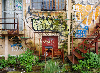 Graffiti on wall of old apartment block with metal staircases