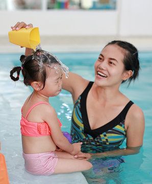 Mother with baby in swimming pool training.