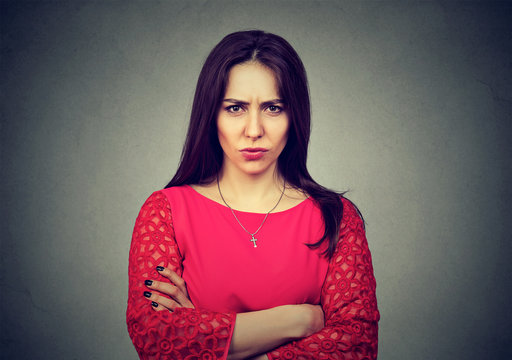 Angry Woman Standing With Arms Folded On Gray Background