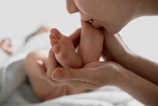 Baby feet which mother kisses