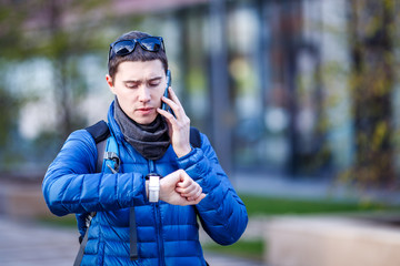 Man talking on phone and looking at smartwatch