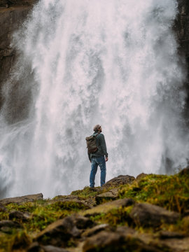 Man on background of waterfall