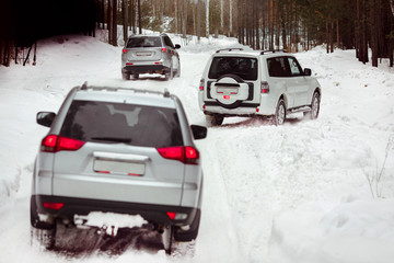 Three SUVs in the woods in winter in the rally