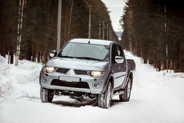 Fototapeta na wymiar SUV rides on a winter forest road