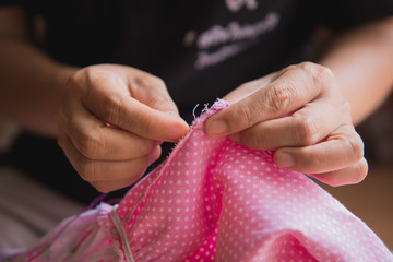 Woman's hand sewing fabric with sewing equipments