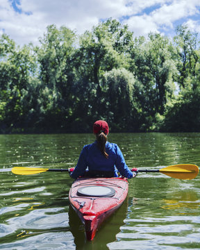 A girl rafts down the river on a kayak.