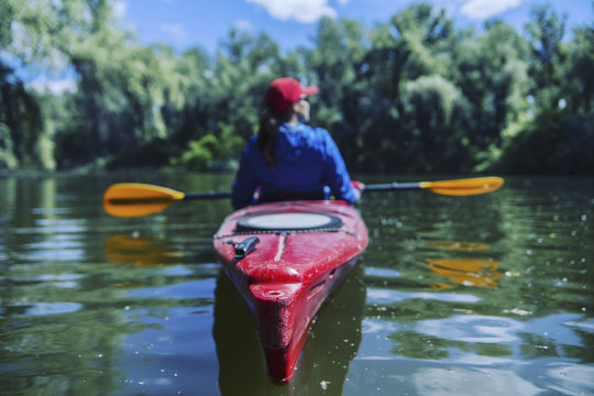 A girl rafts down the river on a kayak.