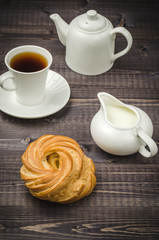 Fototapeta na wymiar white coffee set and roll/cup of coffee, creamer, teapot and sweets