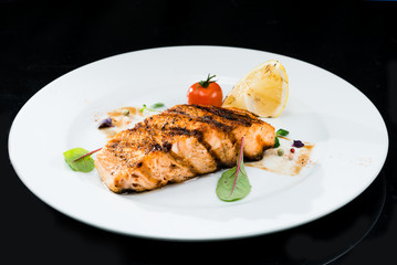 Grilled salmon steak on a dark background
