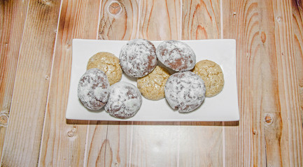 Fototapeta na wymiar Round cookies stack on a white plate, powder sugar, wood background