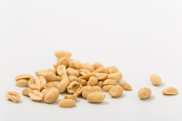 Fried salted peanuts on white background. snack.