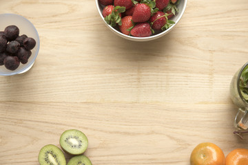 Strawberries, oranges, kiwi fruit, cherries on a wooden background with copy space 