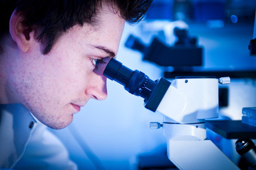 Scientist using microscope in lab