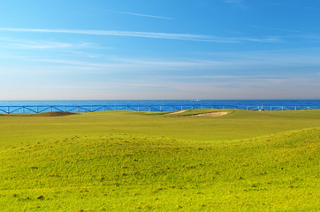 Fototapeta na wymiar Green golf field on the sunny coast of Mediterranean sea