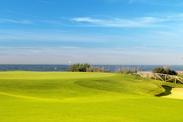 Green golf field on the sunny coast of Mediterranean sea