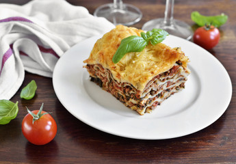 Fresh italian meat lasagne with cherry tomatoes. Italian pasta dish on a white plate.