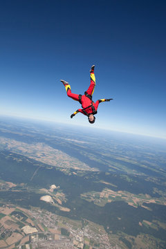 Woman skydiving over rural landscape