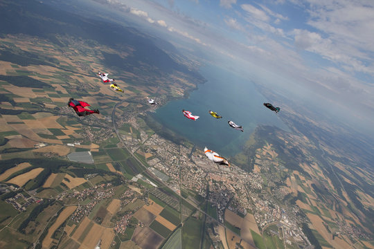 People skydiving over rural landscape