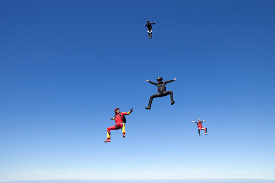People skydiving over clouds
