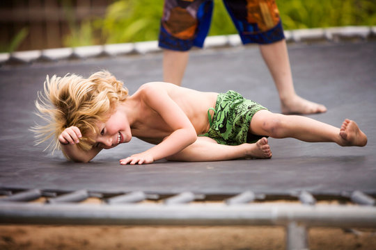 Boys jumping on trampoline outdoors