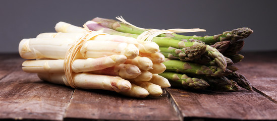 Bunch of fresh white asparagus and green asparagus on table