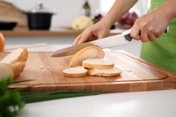 Close up of woman's hands cooking in the kitchen. Housewife slicing white bread. Vegetarian and healthily cooking concept.