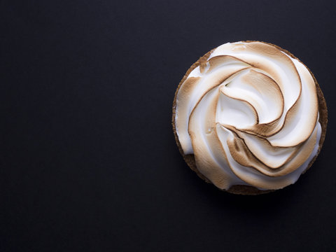 French lemon pie with meringue on top isolated on black background