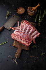 Raw rack of lamb with spices on a cutting board