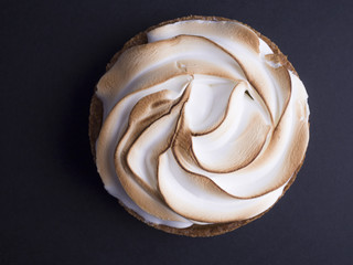 French lemon pie with meringue on top isolated on black background