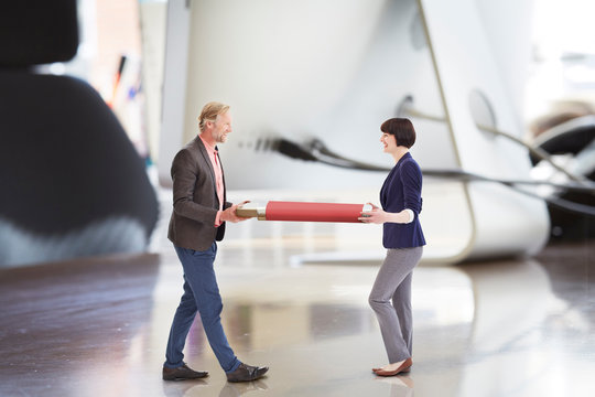 Office colleagues carrying large USB stick on oversized desk