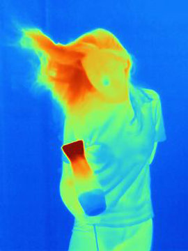 Thermal image of young woman drying her hair