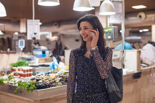Woman on cell phone in fish market