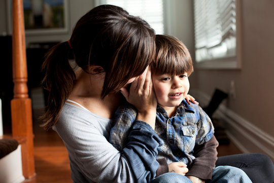 Mother whispering to young son
