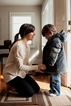 Mother putting on son's coat