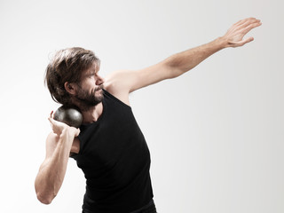 Athlete performing shot put against white background