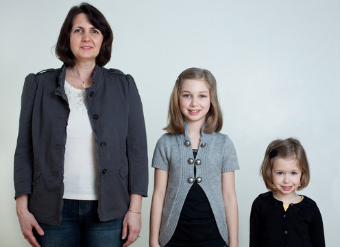 Mother and two daughters standing together, portrait