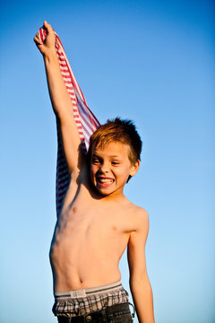 Boy holding striped fabric, arm raised