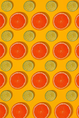 Grapefruit and lime pattern on yellow background. Minimal flat lay concept.