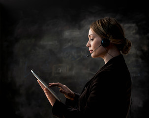 Businesswoman wearing telephone headset using digital tablet
