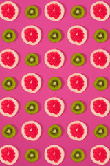 Grapefruit and kiwi pattern on pink background. Minimal flat lay concept.
