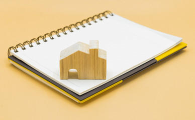 Wooden house model and Pencil on Notebook, Plan to buy a house in the future concept. copy space.